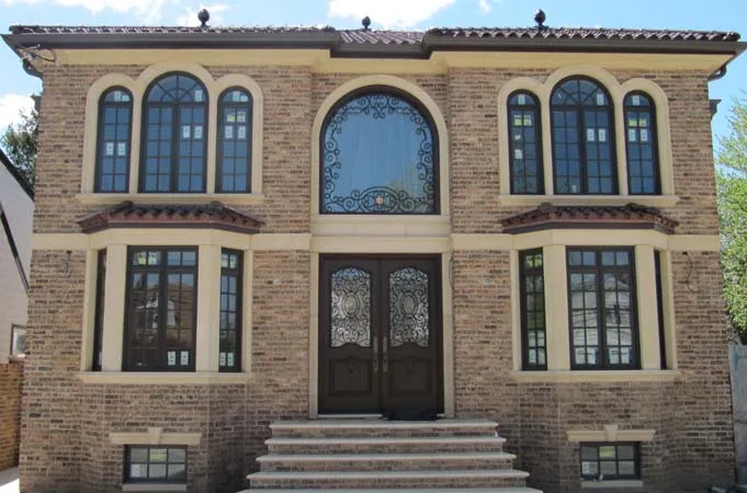Brick house with wood double doors and iron-grille glass under an arched window