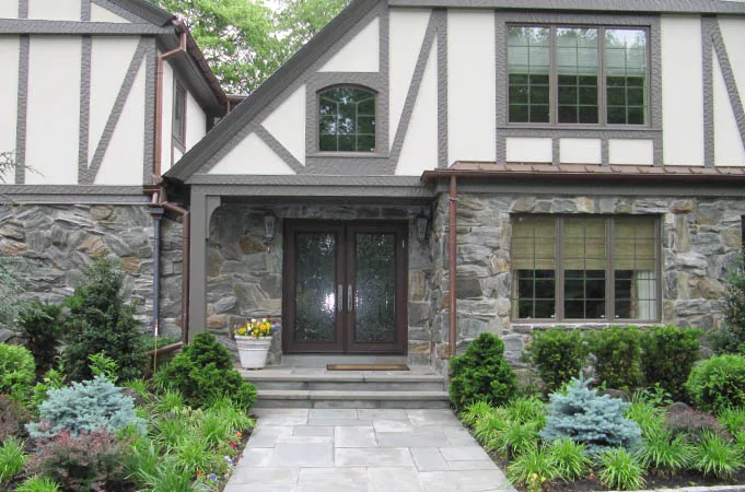 Wood double doors with glass in a stone and half-timbered entry